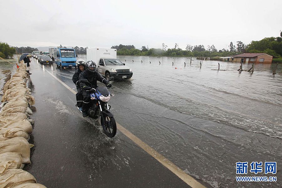 图为5月16日，车辆在哥伦比亚波哥大附近被洪水淹没的街道上行驶。