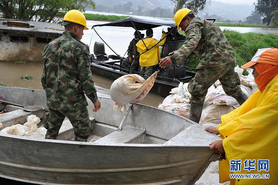 图为5月16日，海军人员在哥伦比亚波哥大附近地区将抗洪沙袋运上船。