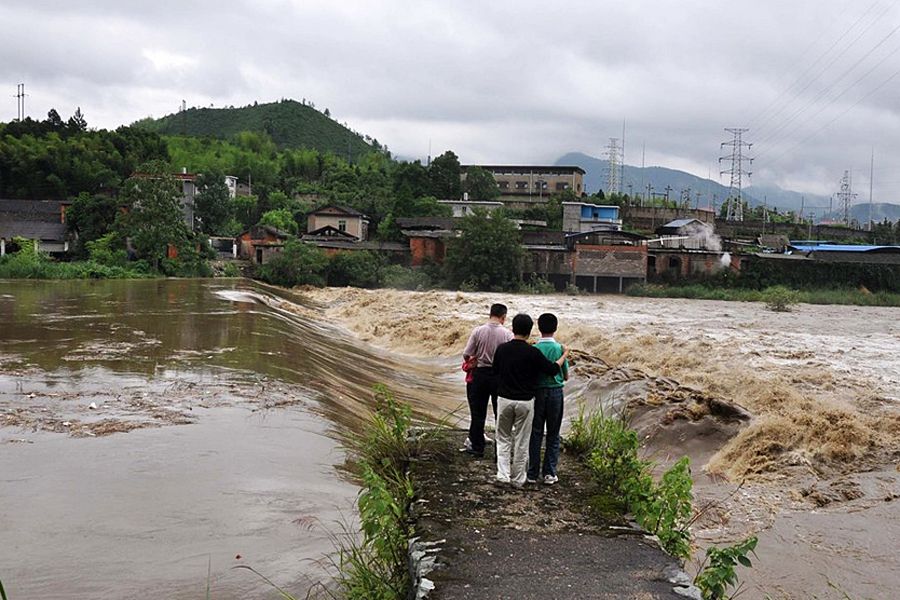 6月6日，江西德兴市，暴雨致洎水河水位上涨，部分农田被淹没。图为市民观看水位暴涨的洎水河。胡敦煌/CFP