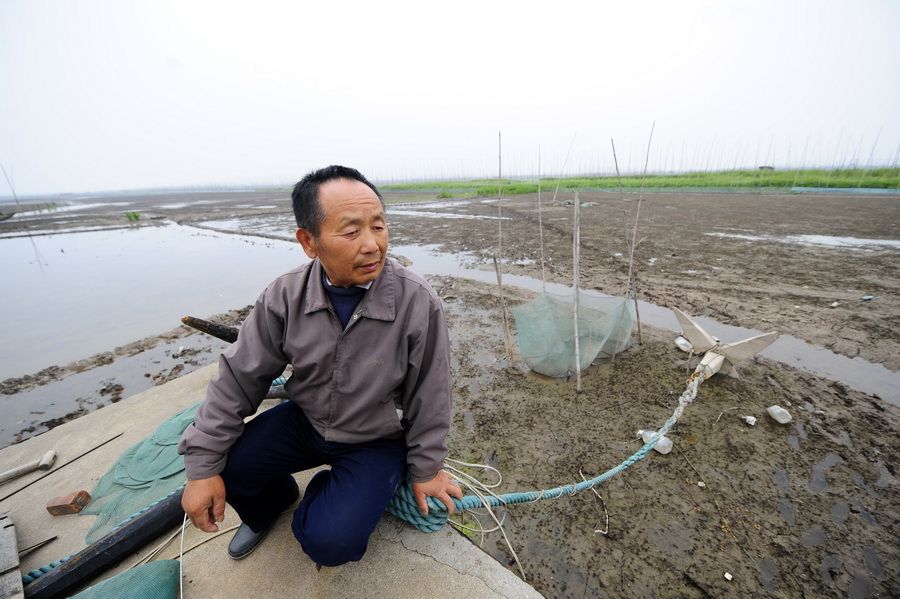 5月24日，渔民舒振家坐在船头看着干涸的湖面一筹莫展。 新华社记者 郝同前 摄