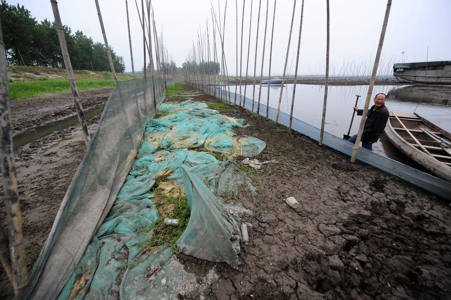 5月24日，一位渔民在整理自家的养鱼围网。 新华社记者 郝同前 摄