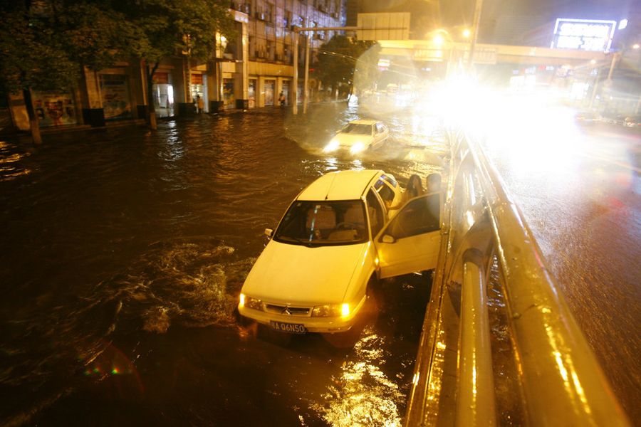 6月9日，湖北武汉，从晚上9时开始持续一个多小时的倾盆暴雨让市区多个路段顿成泽国，一辆汽车在渍水路段抛锚，车主只能弃车而去躲避暴雨。远征/CFP