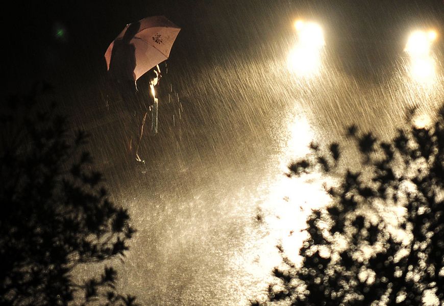 6月9日21时左右，武汉天空暴雨闪电，武昌万科城市花园旁，一女士打着雨伞在暴雨中候车。 shepherd c.zhou/CFP
