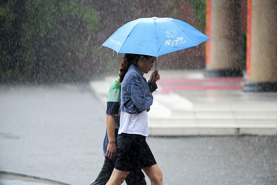 6月14日，湖北24县市出现暴雨天气，武汉街头，两位行人在雨中前行。