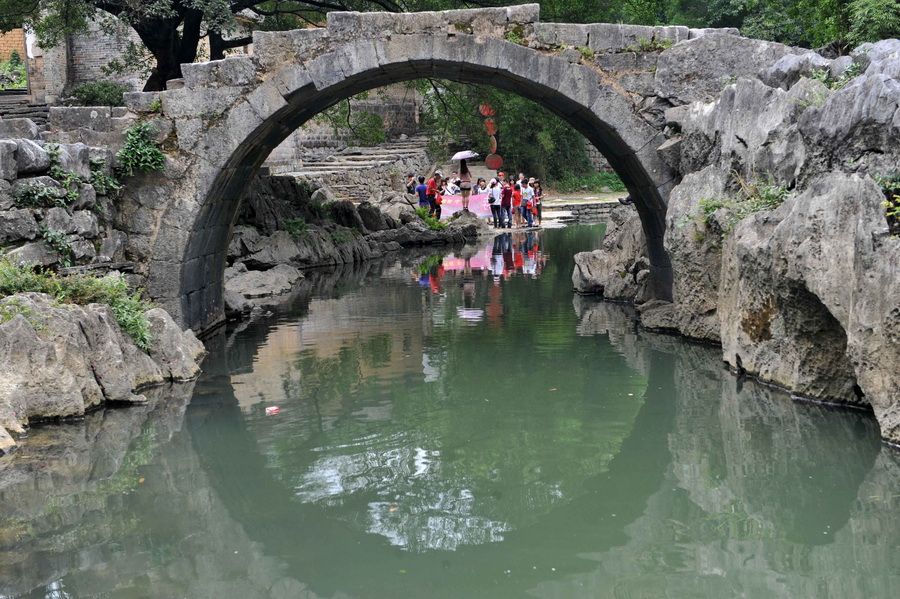 在广西昭平县黄姚古镇带龙桥景点，垃圾漂浮在墨绿色的水面上。