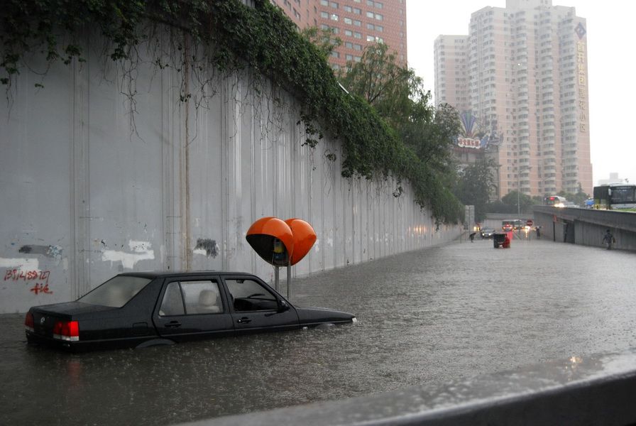 6月23日，北京西三环莲花桥附近，一辆汽车被积水包围。