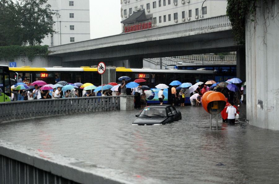 6月23日，北京西三环莲花桥附近，车辆和市民涉水前行。