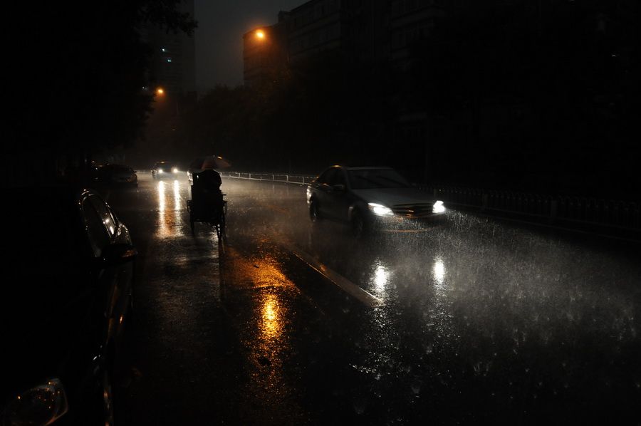 6月23日，北京街头，车辆在雨中行驶。