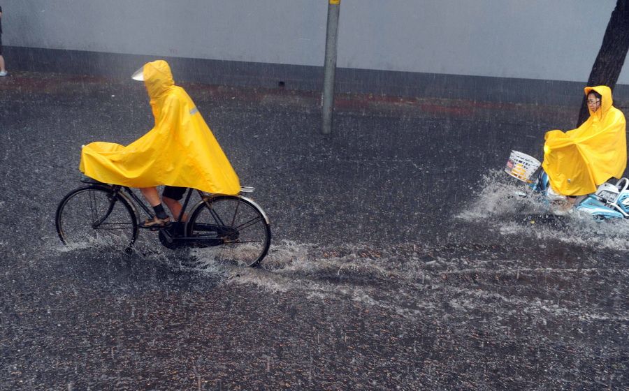 6月23日，北京，骑车人涉水行进。