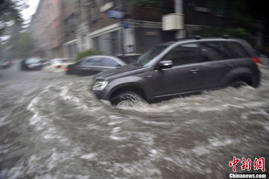 6月23日，北京，一辆汽车在积水中行驶。