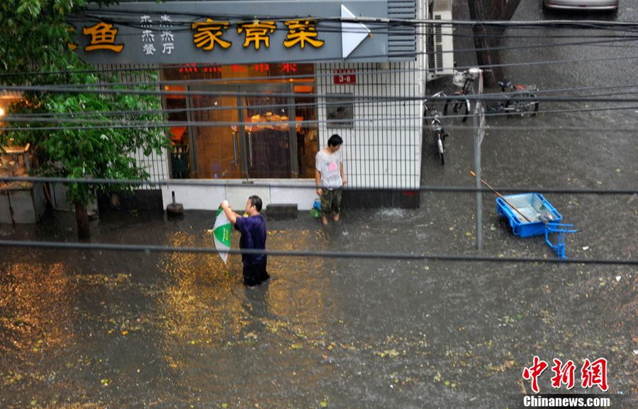 6月23日，北京，被积水围困的行人。