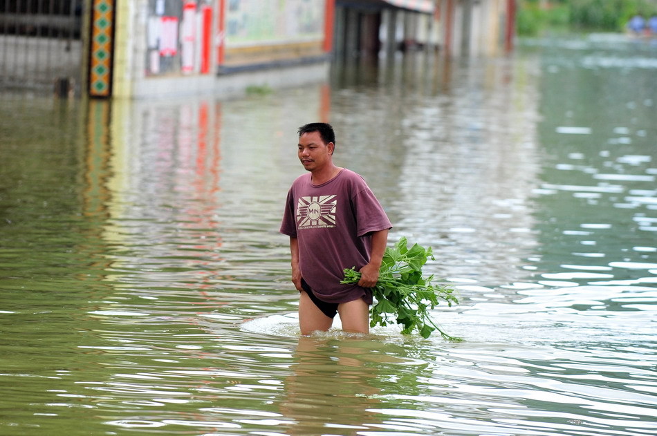 居民在积水成河的街道上涉水行进