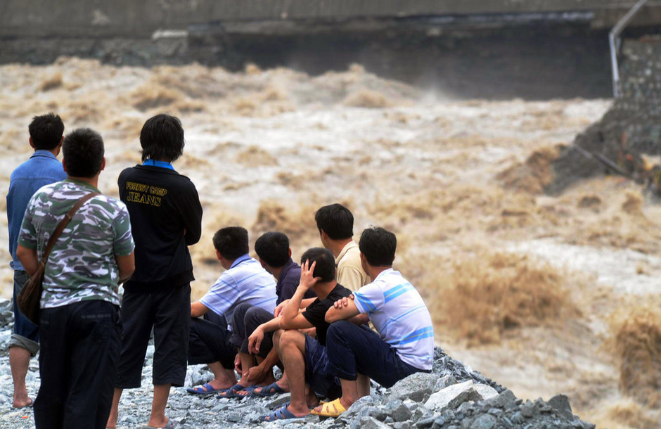 7月3日，213国道映秀至汶川段的一处塌方处，人们正在查看被泥石流冲毁的路基。
