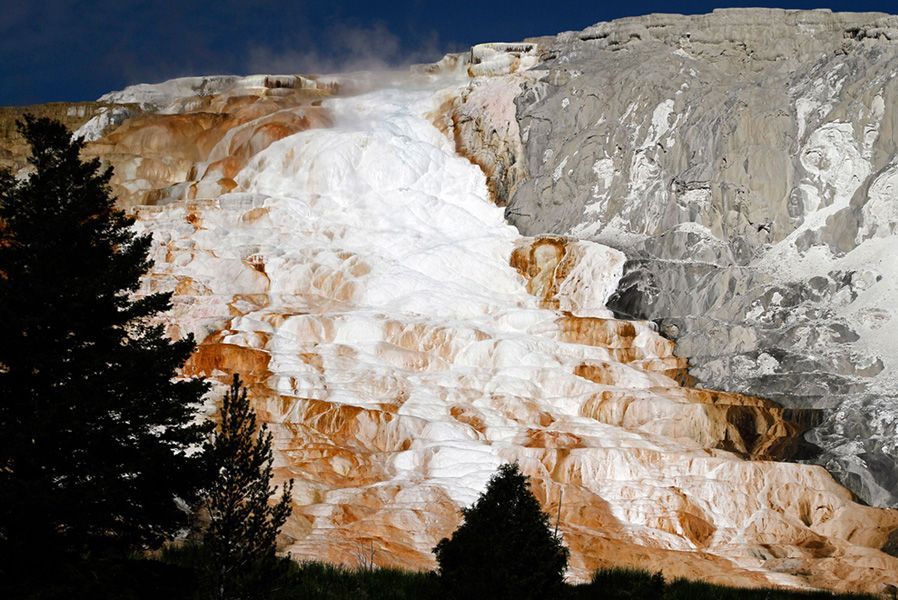 6月2日，黄石公园西拇指间歇泉盆地，间歇泉（前）的硅石和部分结冰的黄石湖（后），形成鲜明颜色对比。