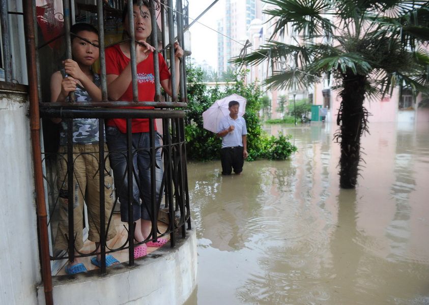 7月11日，合肥翠微路一小区的居民在阳台查看内涝情况。