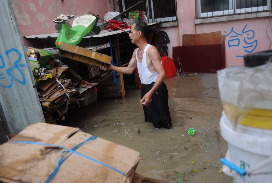 7月11日，合肥翠微路一小区的居民收拾被水浸泡的物品。