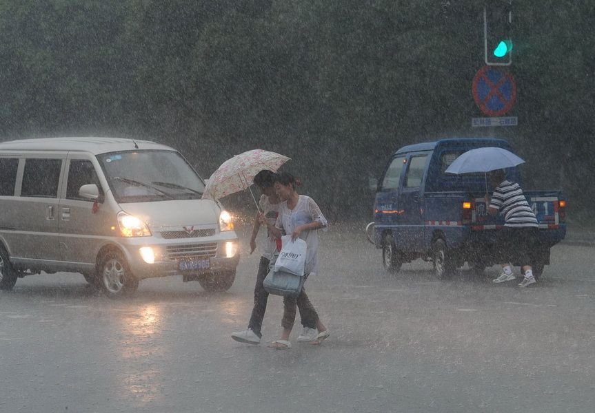 7月11日，合肥市民在暴雨中前行。