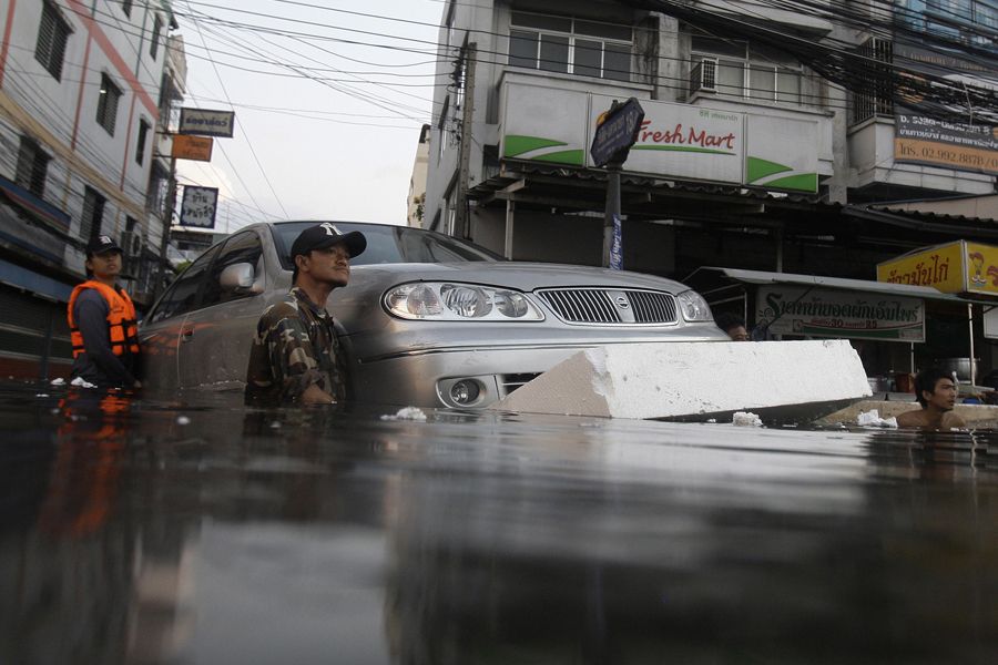 当地时间10月27日，曼谷市郊居民已经开始撤离洪水危险地带。人们试图用泡沫让车漂浮在洪水上，转移财产。