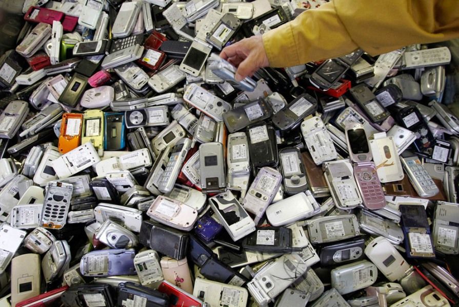 2011年10月15日，日本利泰姆公司位于东京的回收间里，一位工人正在处理回收而来的废旧手机。