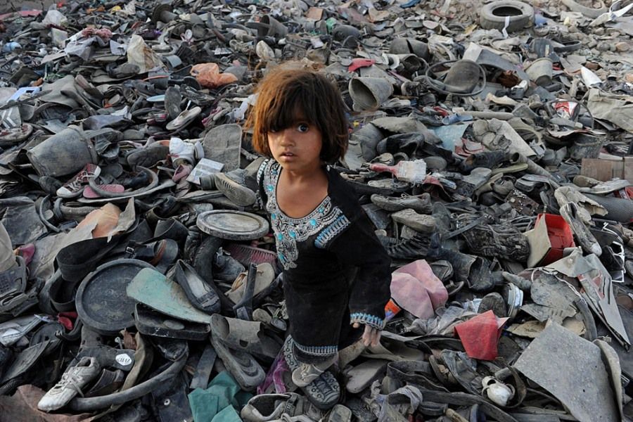 2011年10月4日，阿富汗喀布尔郊外，一位小女孩正在垃圾堆里寻找可以回收利用的废弃物。